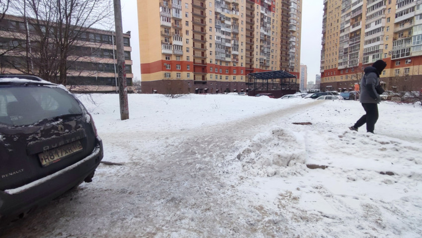 Заснеженный двор с жилыми высотками и припаркованными машинами