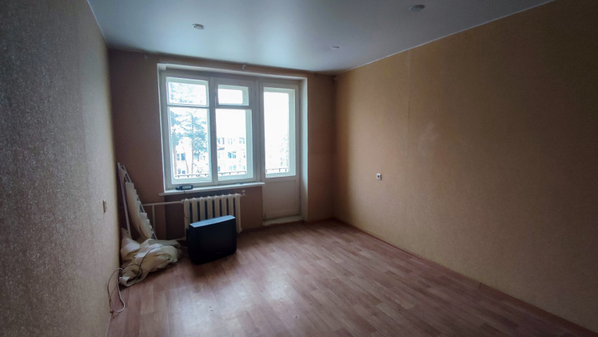 Пустая комната с окном и радиатором отопления