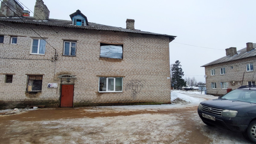 Фасад двухэтажного кирпичного жилого дома зимой