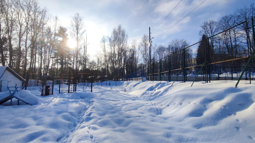 Снежная площадка у лесополосы с ограждением