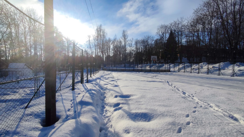 Баскетбольная площадка под снегом в зимнем парке