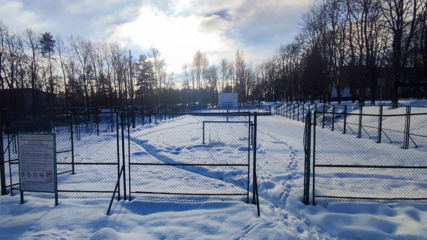 Огороженная спортивная площадка с воротами в зимний день