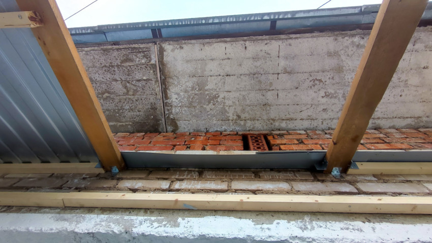 Кровельные балки и кирпичная кладка на стадии монтажа
