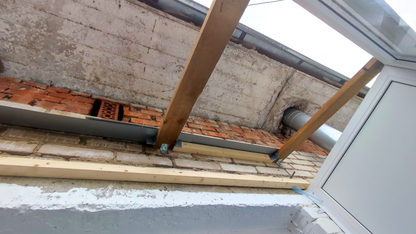 Балконная крыша с видом на кирпичную кладку и вентиляционный канал