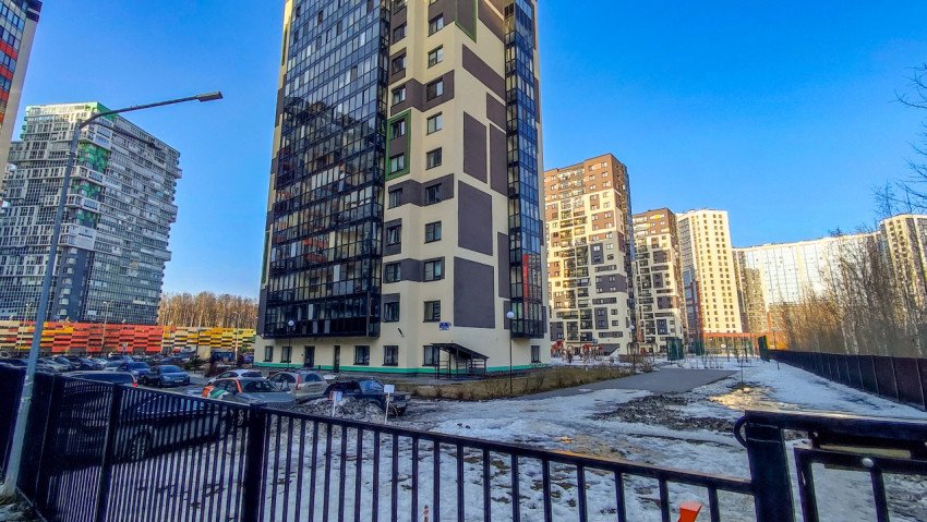 Двор жилого квартала рядом с парковкой и ограждением