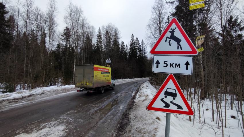 Грузовой автомобиль и предупреждающие знаки на зимней дороге