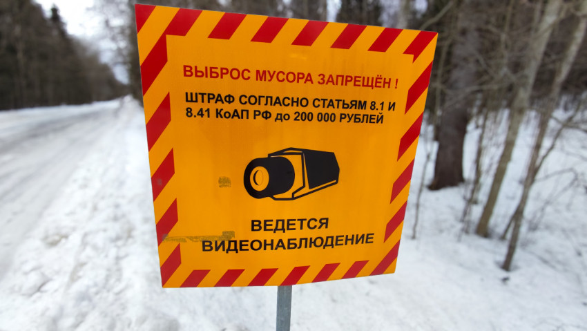 Предупреждающий знак о штрафе за выброс мусора на зимней дороге