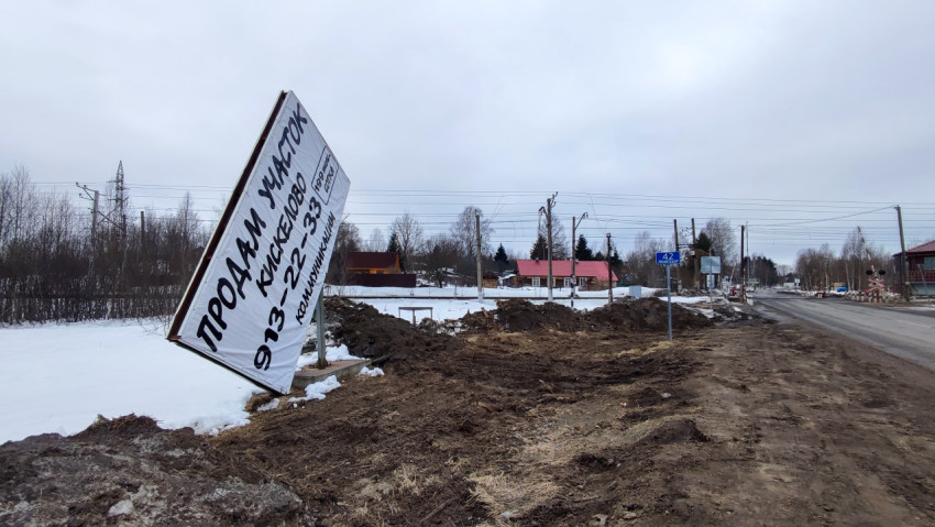 Рекламный щит и знак Росавтодора у железнодорожного переезда