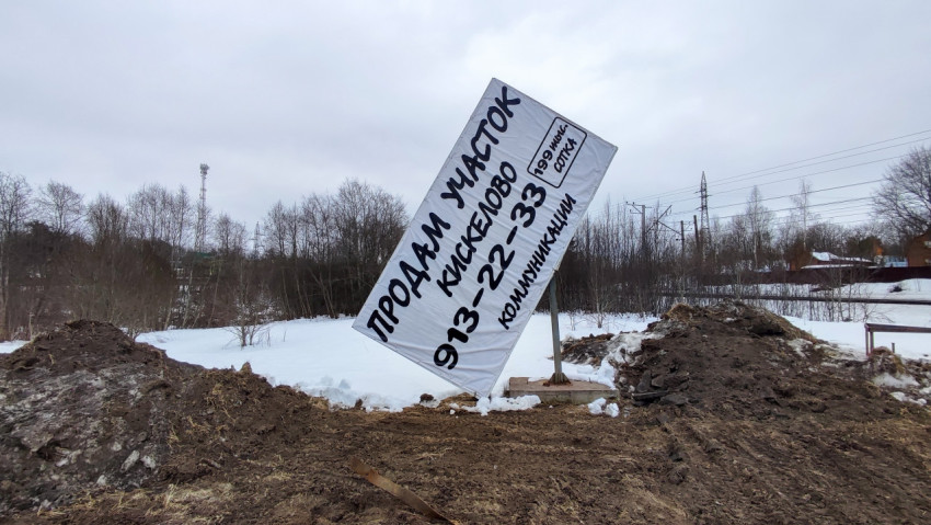 Рекламный баннер на обочине дороги в зимнем пейзаже