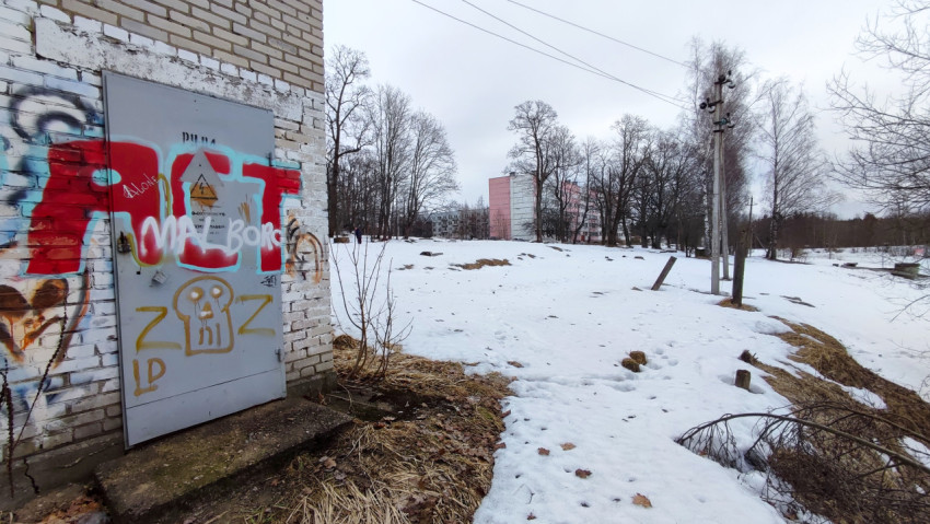 Старая кирпичная постройка с граффити на фоне зимнего пейзажа