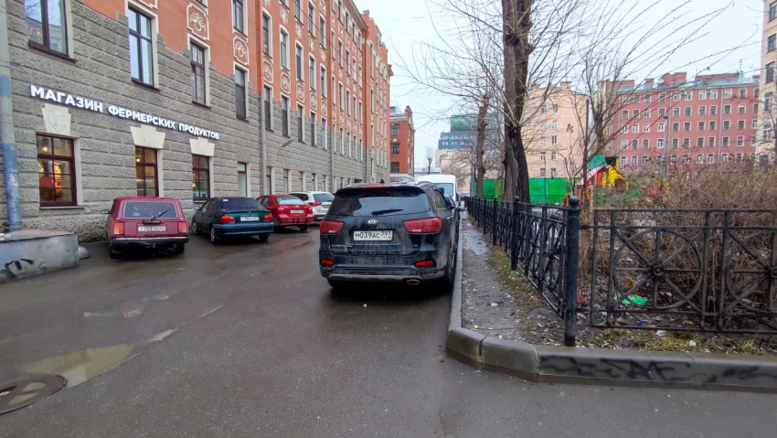 Двор старинного жилого дома с парковкой и детской площадкой