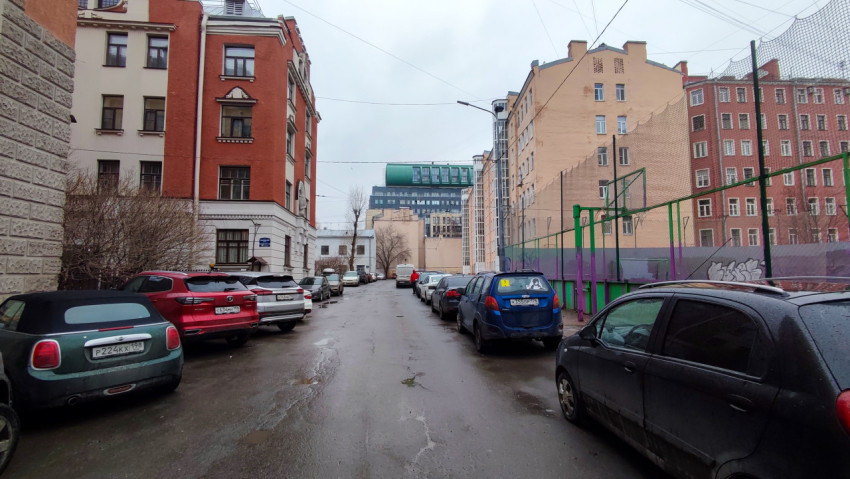 Улица между домами с парковкой и спортивной площадкой