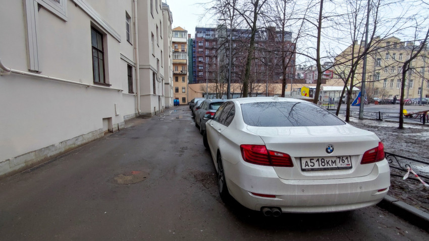 Парковка автомобилей вдоль стены жилого дома