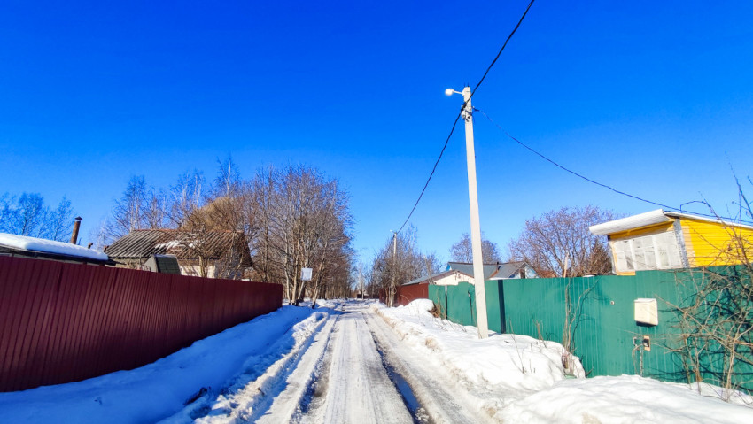 Узкая зимняя улица с опорой и освещением