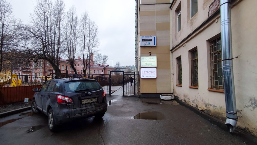 Въезд во двор жилого комплекса с парковкой и вывесками компаний