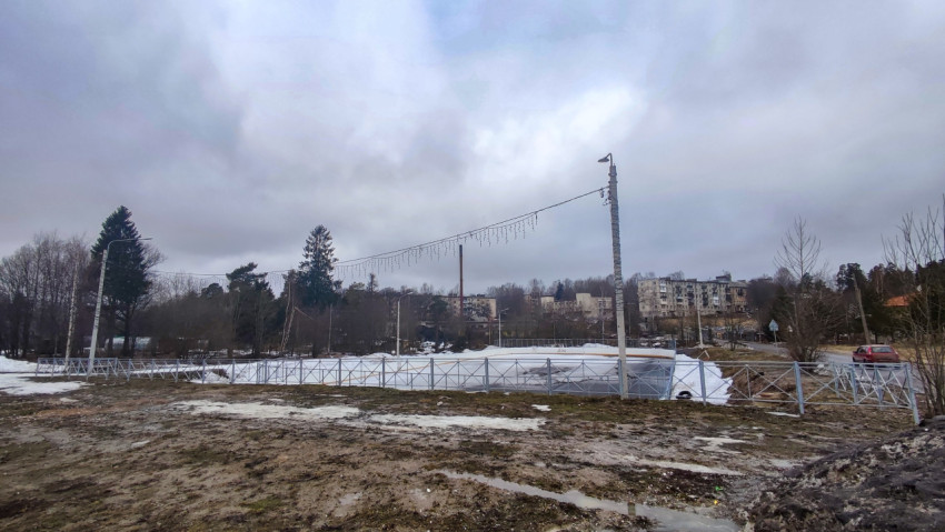 Пустырь с ограждением и праздничной иллюминацией в жилом районе