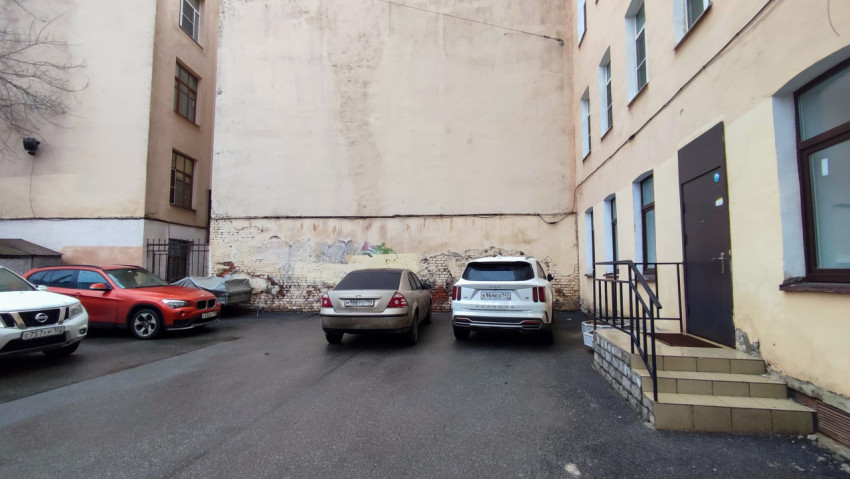 Парковка между жилыми зданиями с видом на старый квартал