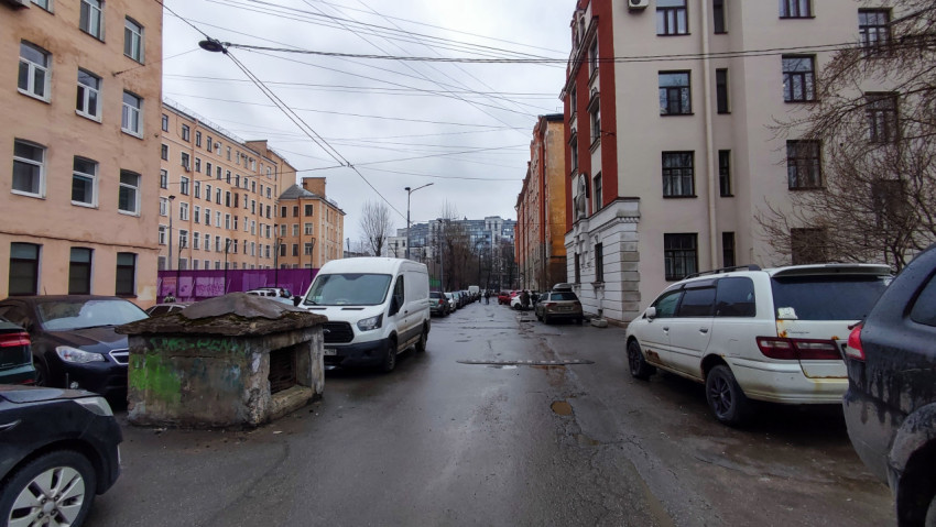 Дворовая улица с жилыми домами и припаркованными машинами