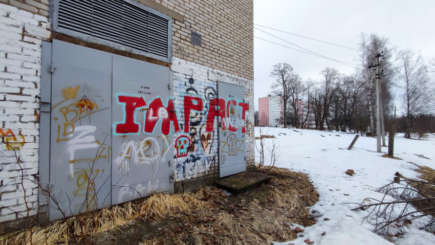 Кирпичное здание с граффити и зимним пейзажем