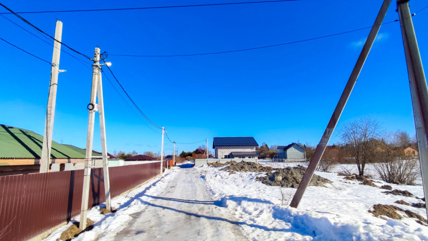 Загородная дорога с электростолбами и частными домами