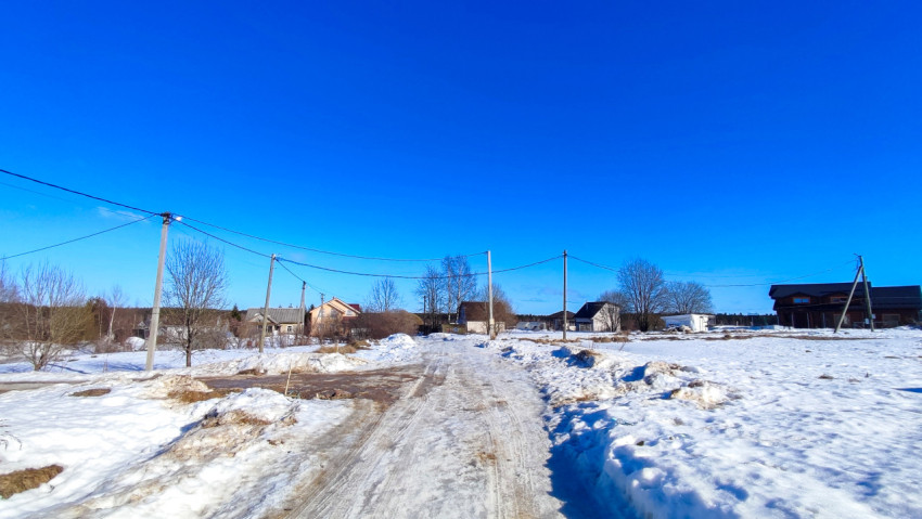 Широкий обзор загородной улицы с опорами воздушной линии