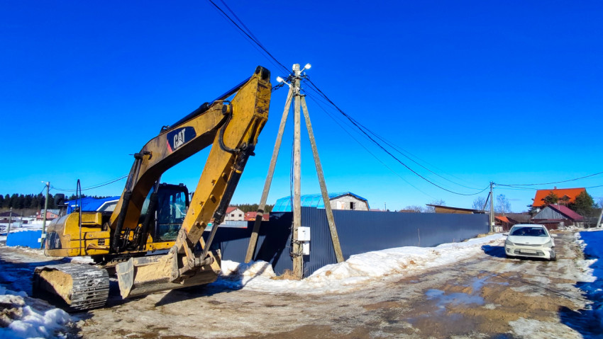 Экскаватор и деревянная опора линии электропередачи