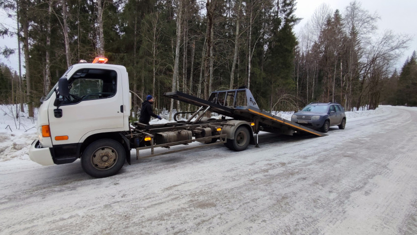 Работа эвакуатора на зимней трассе с внедорожником
