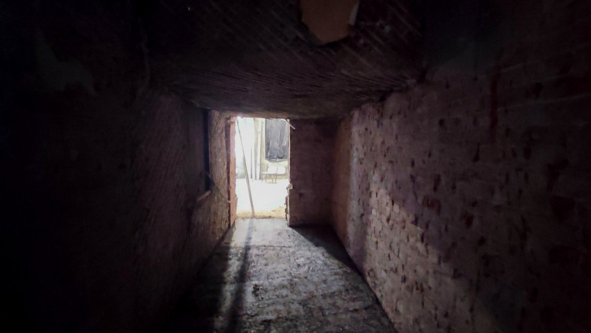 Узкий кирпичный коридор в подвале старого здания