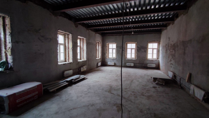 Помещение с металлическими балками и окнами старого здания