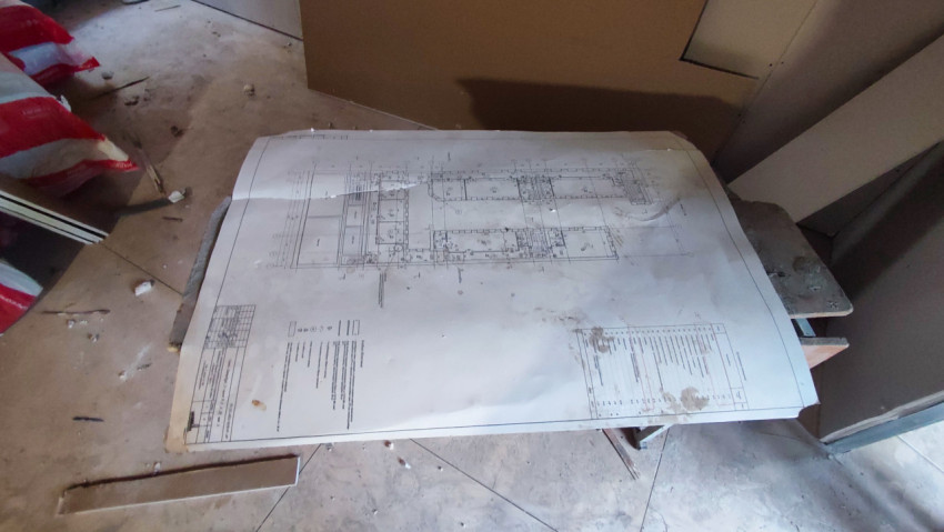 Архитектурный чертёж на строительном столе в процессе ремонта