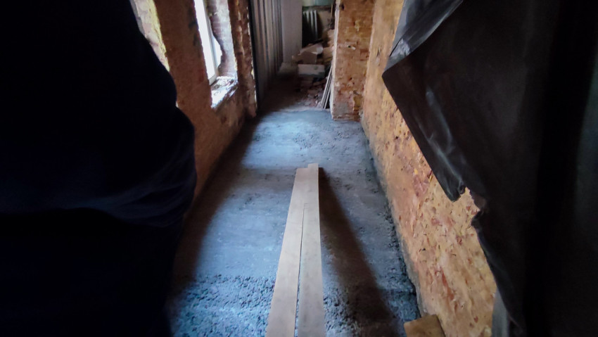 Узкий проход с кирпичными стенами в процессе реставрации