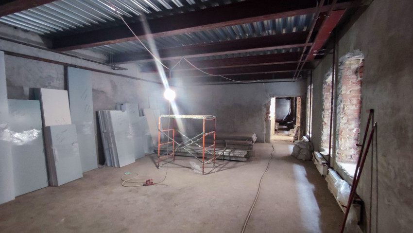 Помещение с металлическими балками и строительными материалами