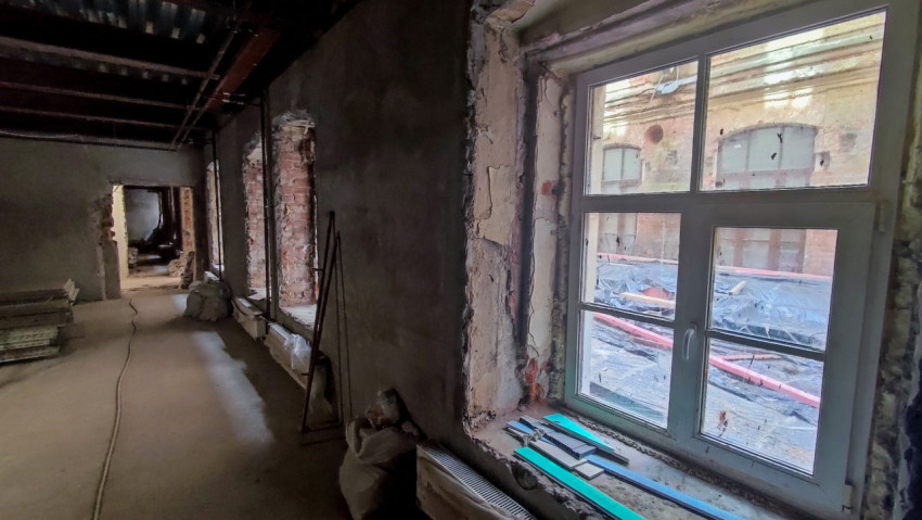 Ремонт внутреннего помещения с видом на старый фасад через окно