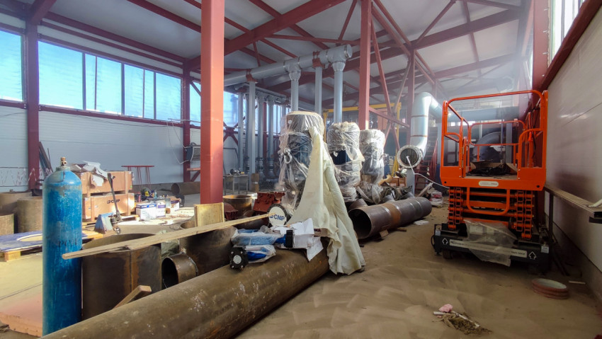 Производственный цех с оборудованием и трубопроводными заготовками