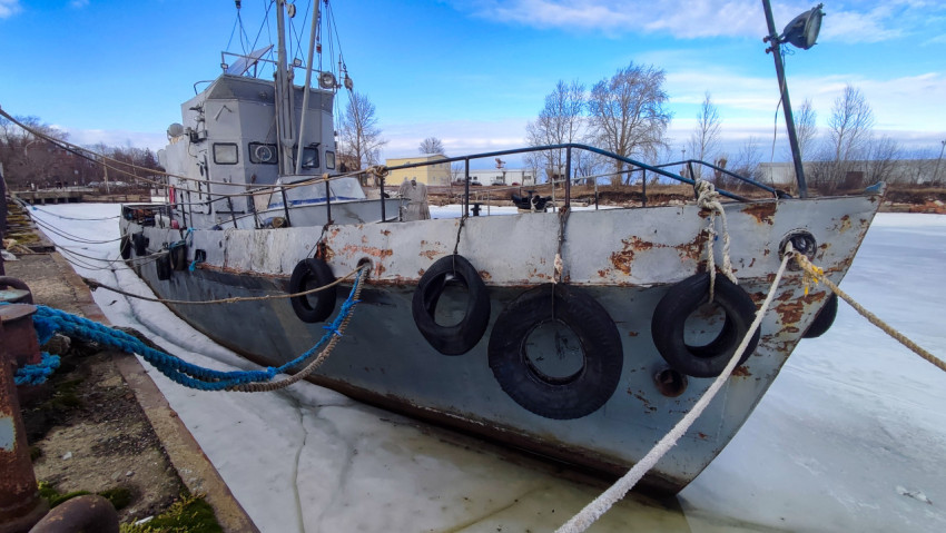 Старое техническое судно с отбойниками из шин