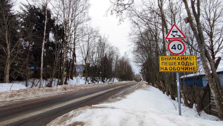 Зимняя дорога со знаками ограничения скорости и предупреждения