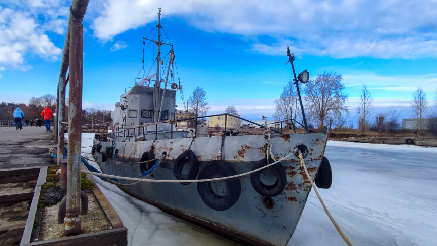 Судно у причала и люди на набережной в зимний день