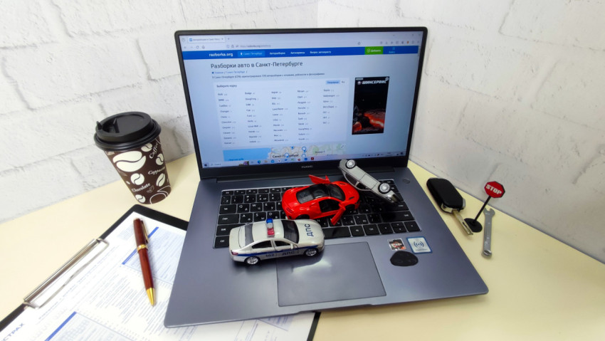 Ноутбук с сайтом razborka.org и игрушечными машинами на клавиатуре