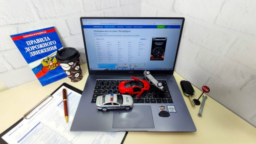 Рабочее место по автомобильной тематике с ноутбуком и книгой ПДД