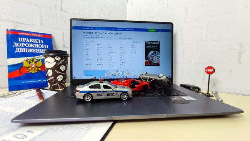 Рабочий стол с ноутбуком, моделями автомобилей и знаком STOP