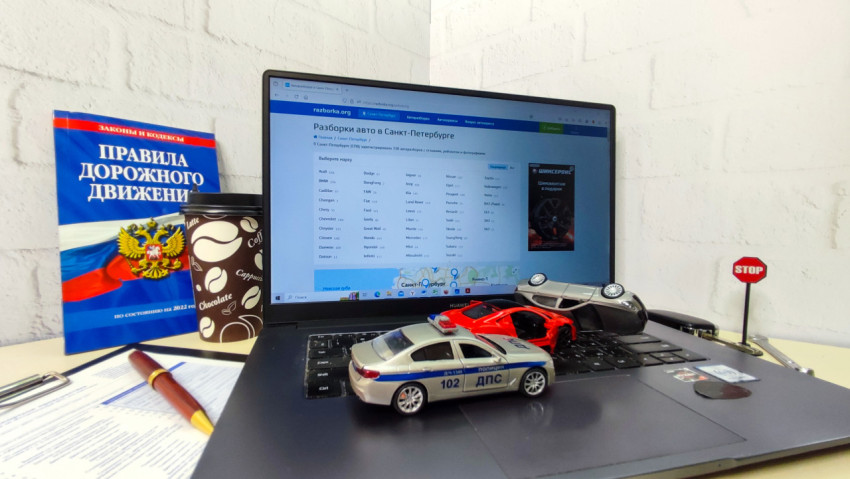 Рабочий стол с ноутбуком, моделями машин и знаком STOP