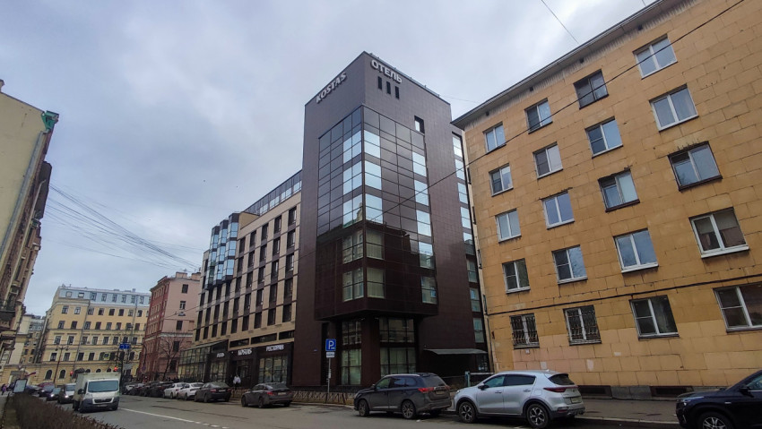 Угловой фасад отеля Kostas на фоне жилых домов