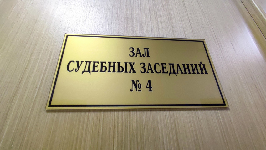 Табличка «Зал судебных заседаний № 4» на светлой деревянной поверхности