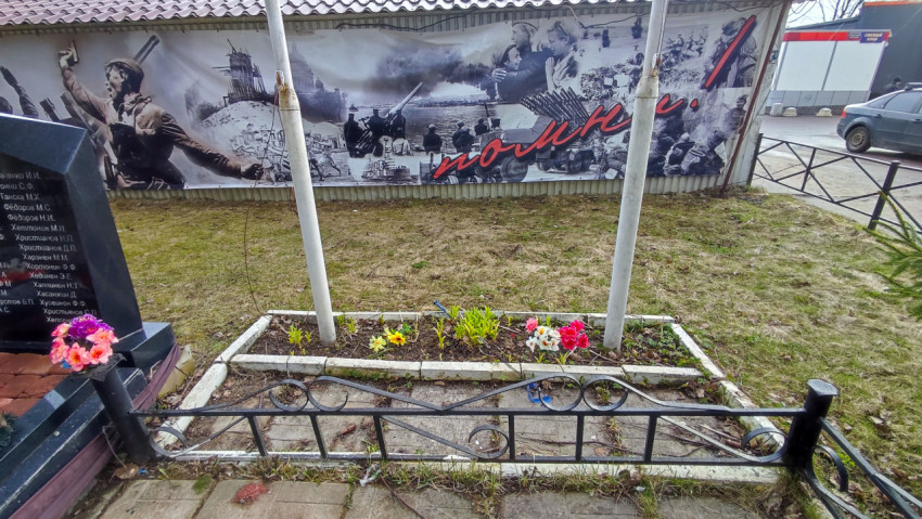 Цветник у флагштоков возле мемориальных плит