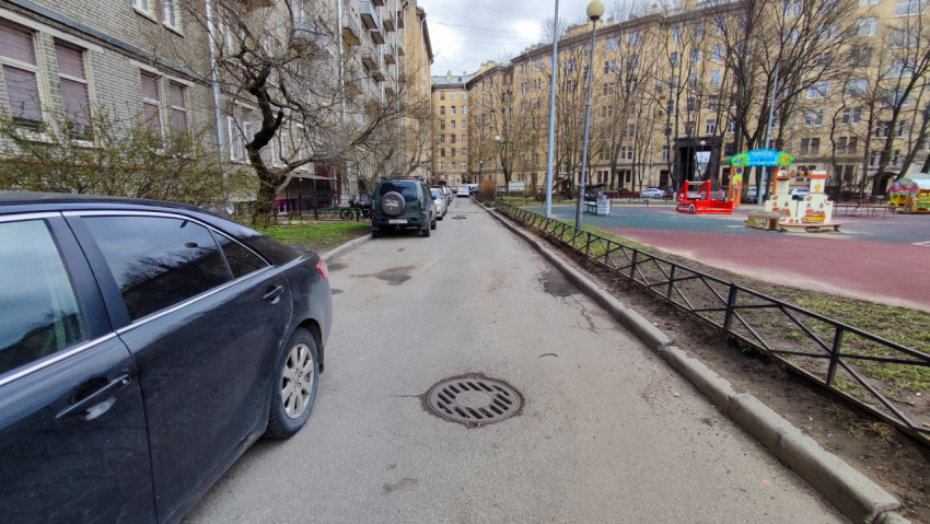 Дворовая улица с припаркованными автомобилями и детской площадкой