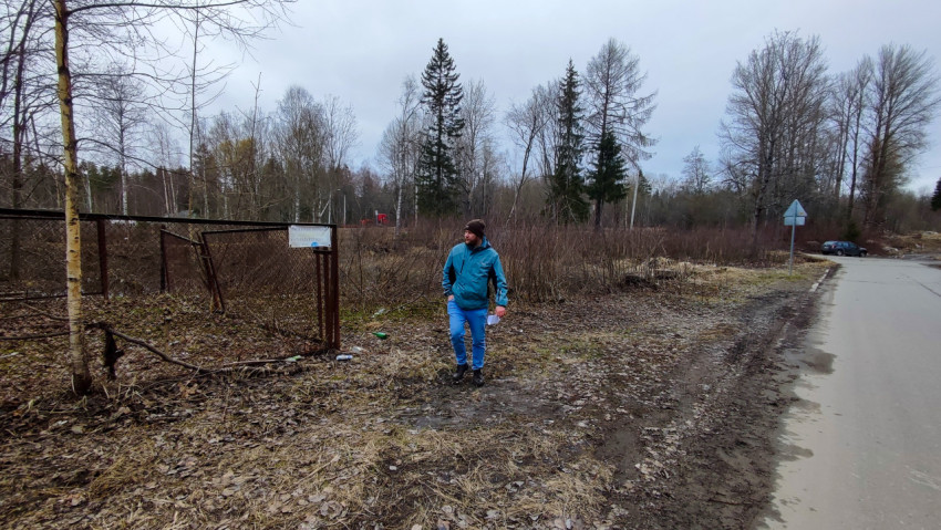 Мужчина у старого ограждения на окраине населённого пункта