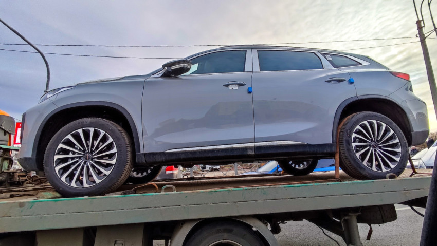 Легковой автомобиль на платформе эвакуатора, снятый сбоку