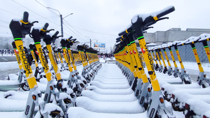 Электросамокаты в снегу возле трамвайных линий