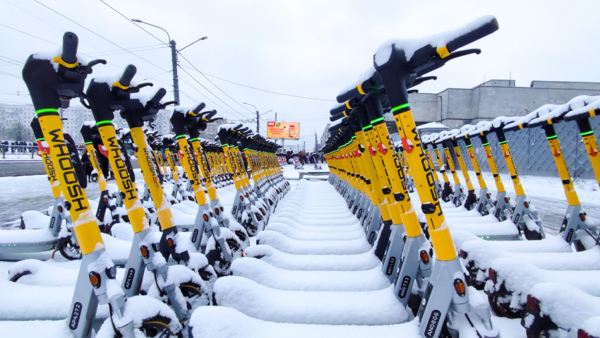 Снежные ряды электросамокатов на открытой городской площадке