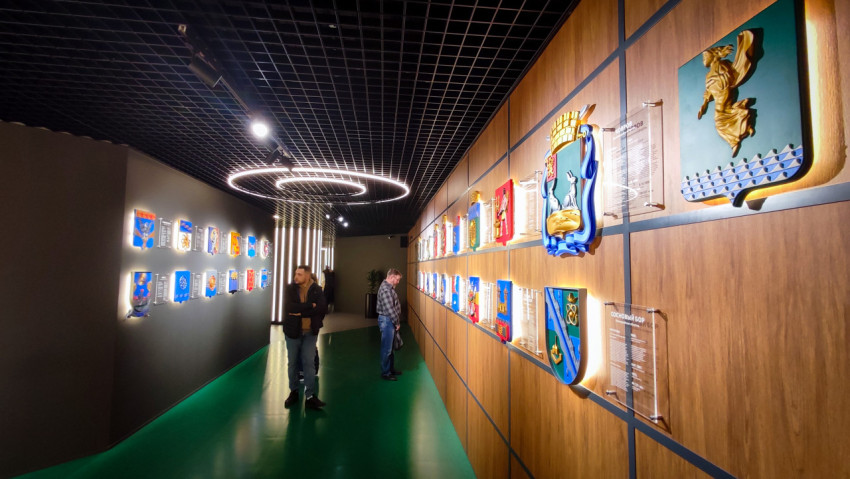 Посетители у стенда городских гербов в павильоне «АТОМ» на ВДНХ